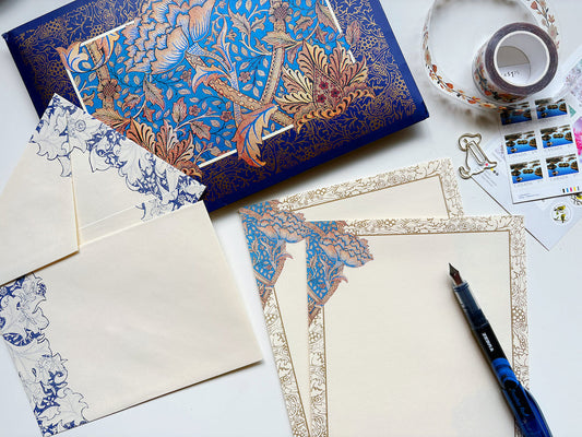 overhead view of William Morris writing paper, a fountain pen, stamps and envelopes